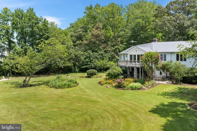 a view of a house with a patio and a yard