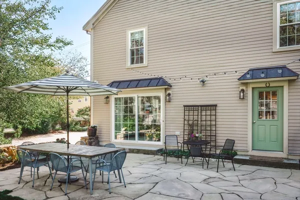 a backyard of a house with a table and chairs