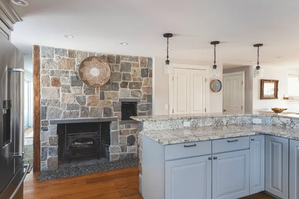 a kitchen with granite countertop a sink cabinets and wooden floor