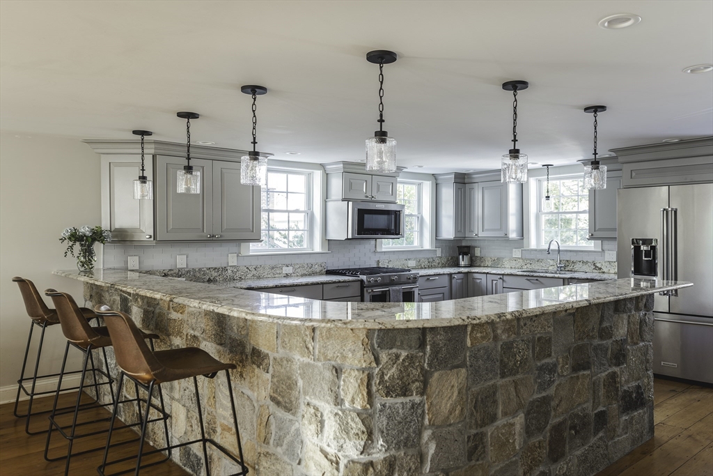 176 Hale Street Beverly, MA 01915 - Photo 8 of 41 a view of a kitchen with kitchen island granite countertop a counter top space a sink stainless steel appliances and cabinets