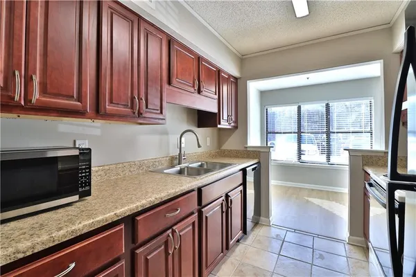 a kitchen with stainless steel appliances granite countertop a sink stove and microwave