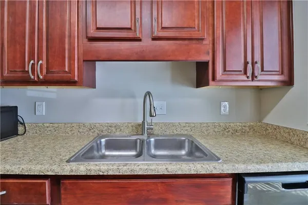 a kitchen with granite countertop a sink a stove and cabinets