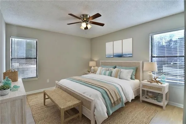 a bedroom with a bed a dresser and potted plant