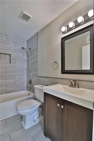 a bathroom with a toilet mirror vanity and tub