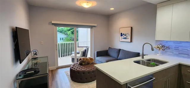 a living room with furniture a flat screen tv and a window