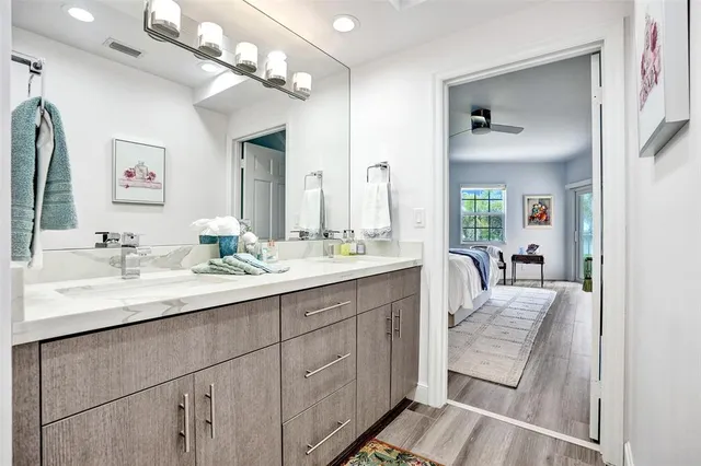 a en suite bathroom with a double vanity sink a mirror and a bathtub