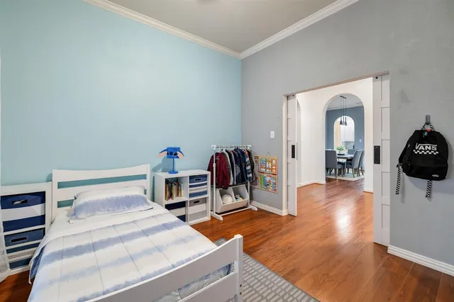 a bedroom with a bed and a wooden floor