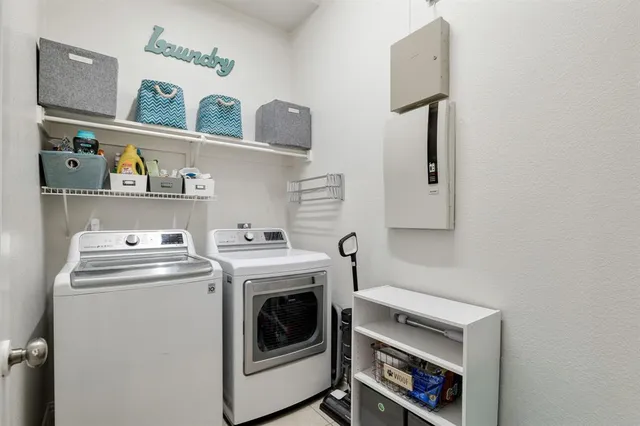 a utility room with dryer washer and empty racks