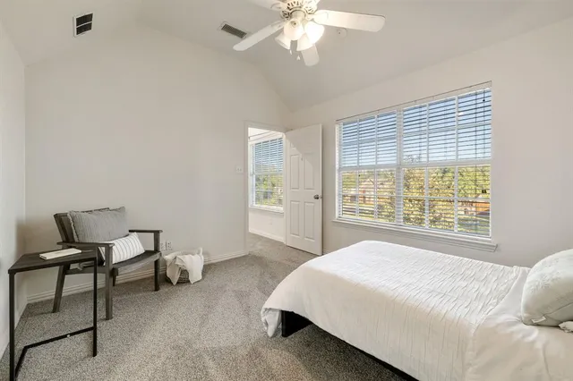 a spacious bedroom with a bed and a chair