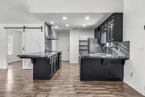 a kitchen with granite countertop a sink stove and cabinets