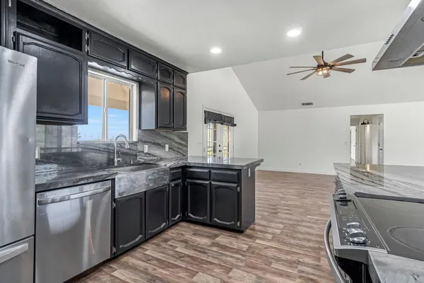 a kitchen with stainless steel appliances granite countertop a sink and stove