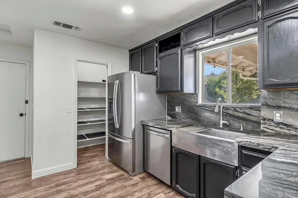 a kitchen with stainless steel appliances granite countertop a refrigerator and a sink