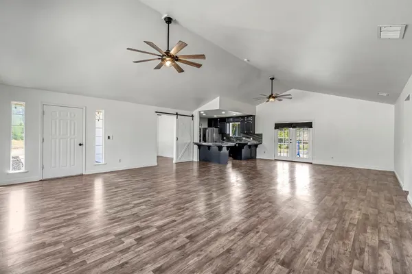 a view of empty room with wooden floor and ceiling fan