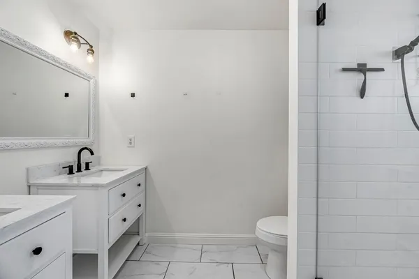 a bathroom with a sink a toilet and a mirror