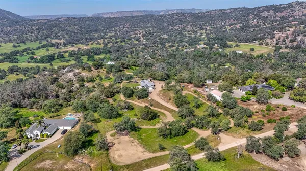 an aerial view of a houses with a lush green hillside