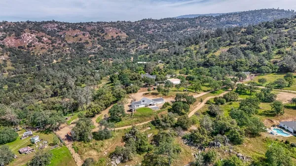 a view of dirt field with trees in the background