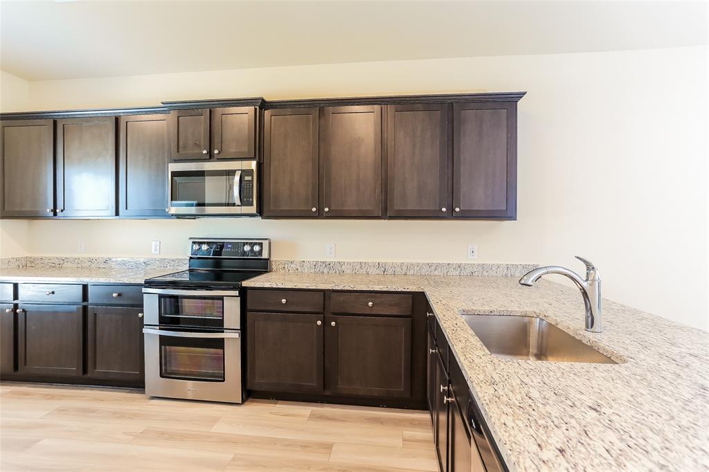 140 Switchback Hl Road Newark, TX 76071 - Photo 11 of 17 a kitchen with a sink stove and microwave