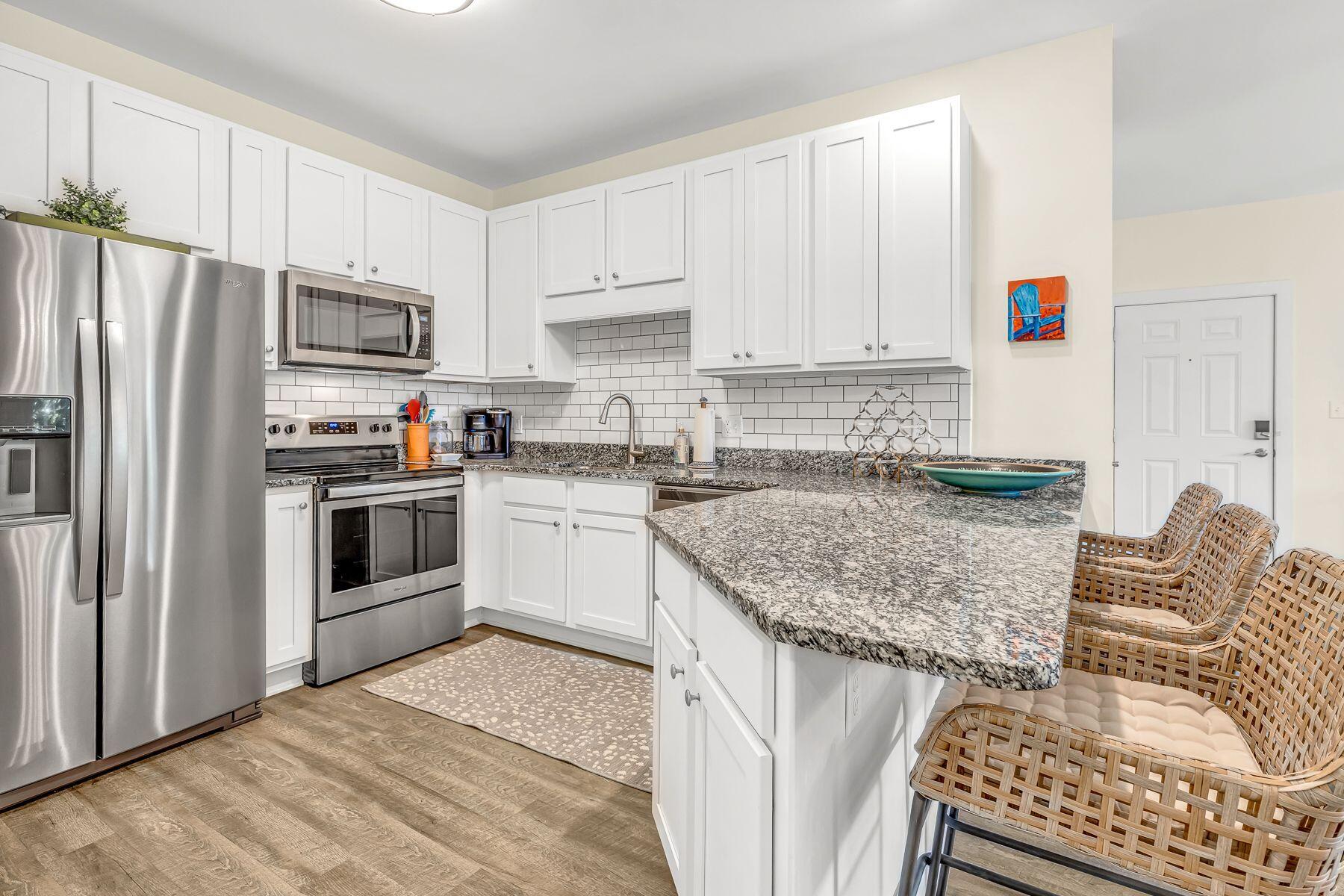 4000 West County Highway 30A, Unit 322 Santa Rosa Beach, FL 32459 - Photo 3 of 30 a kitchen with granite countertop a sink stainless steel appliances and white cabinets