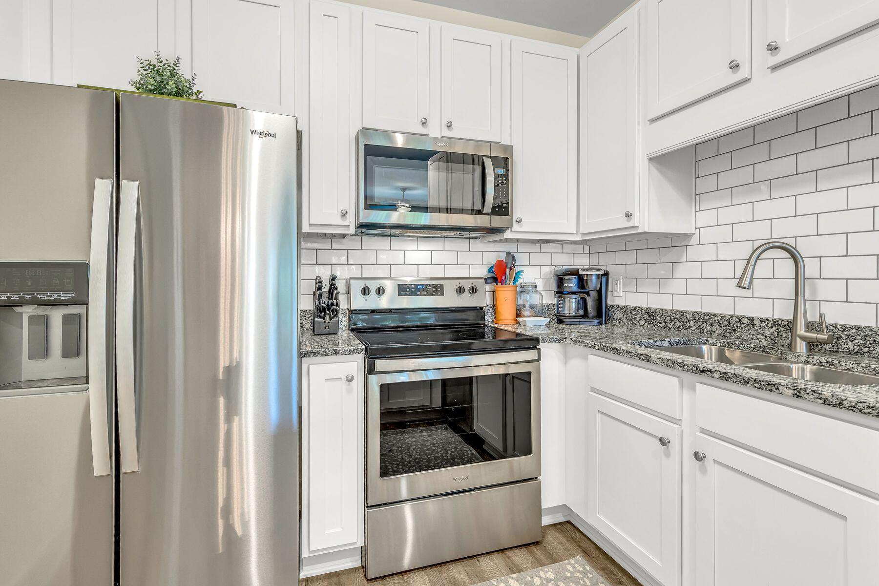 4000 West County Highway 30A, Unit 322 Santa Rosa Beach, FL 32459 - Photo 6 of 30 a kitchen with granite countertop white cabinets and stainless steel appliances