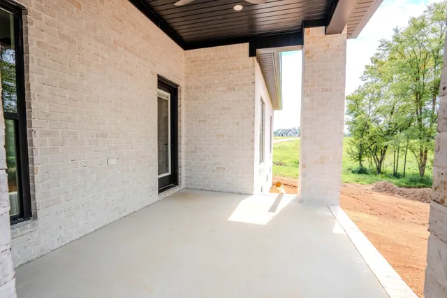 a view of an empty room with a floor to ceiling window and trees