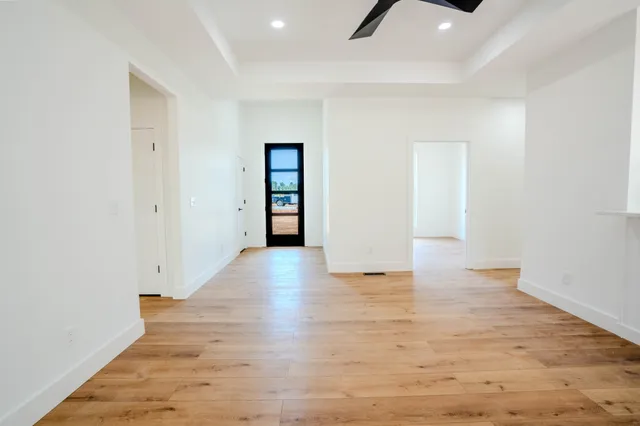 a view of a kitchen with wooden floor fridge and windows