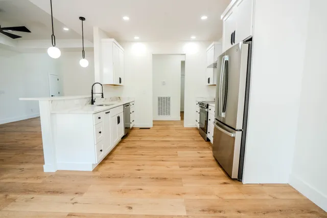 a kitchen with a sink cabinets and wooden floor