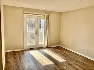 an empty room with wooden floor and windows