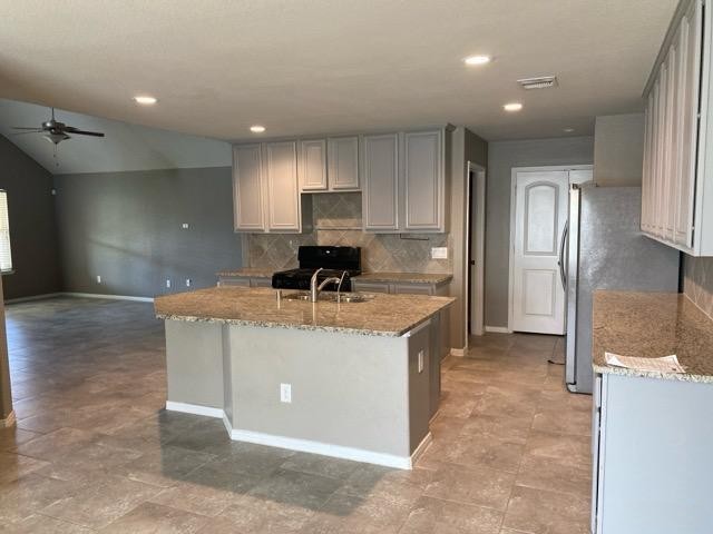 18003 Svensson Slade Lane Houston, TX 77044 - Photo 17 of 24 a kitchen with kitchen island a sink stainless steel appliances and cabinets