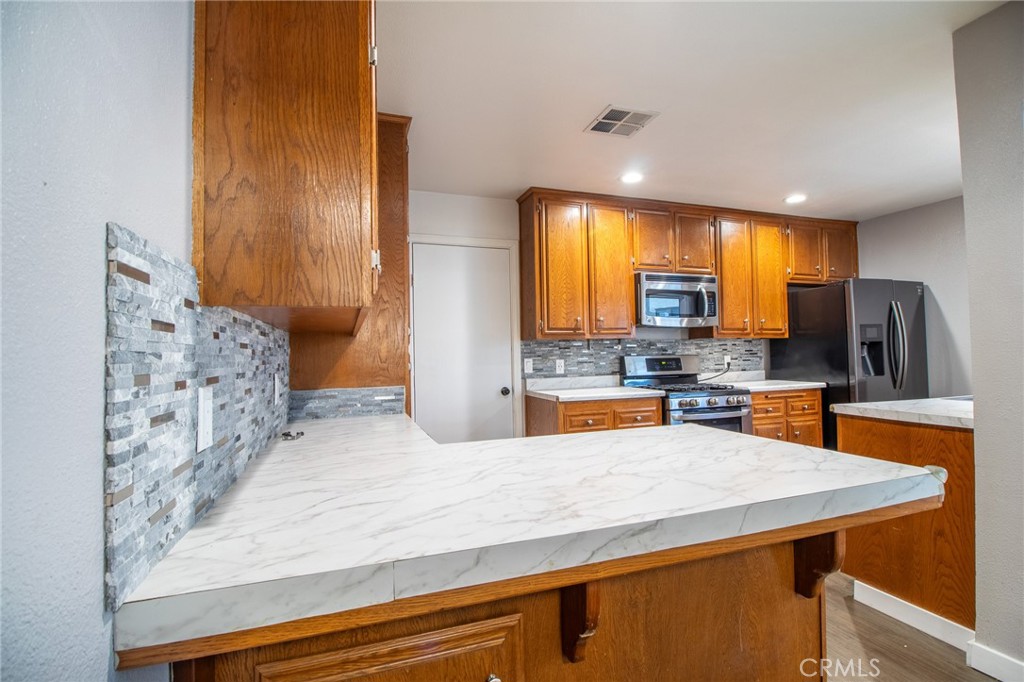 3112 Lynae Way Hemet, CA 92545 - Photo 8 of 26 a kitchen with stainless steel appliances granite countertop a sink a stove and a wooden floors