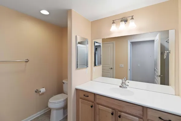 a bathroom with a granite countertop sink toilet and mirror