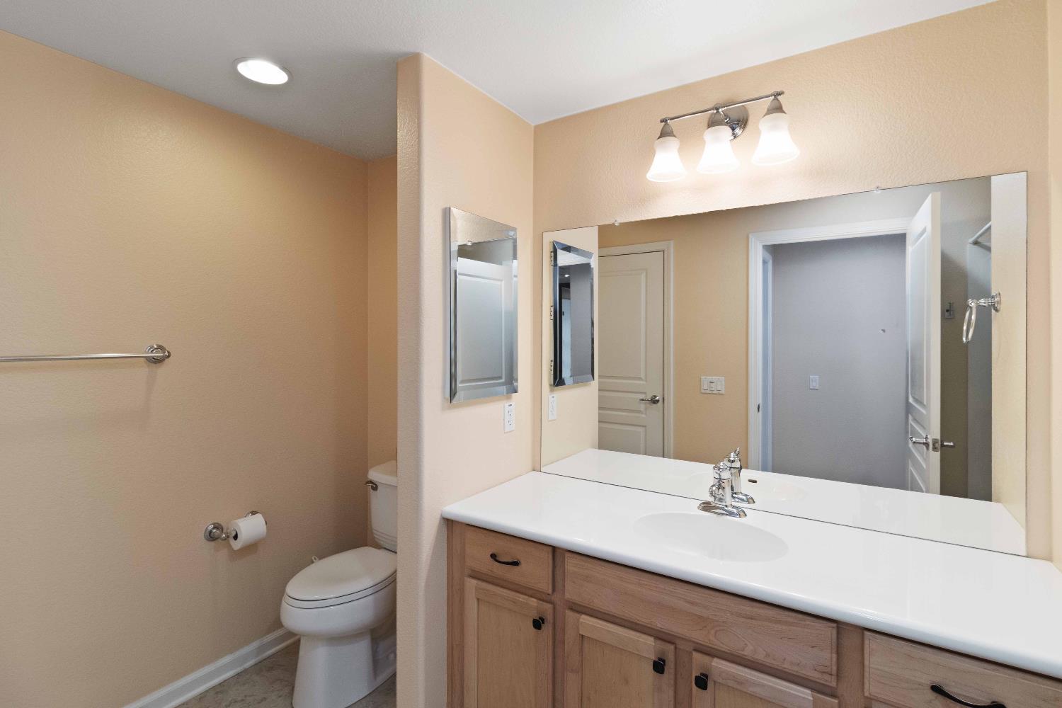 1550 Topanga Lane, Unit 101 Lincoln, CA 95648 - Photo 19 of 27 a bathroom with a granite countertop sink toilet and mirror