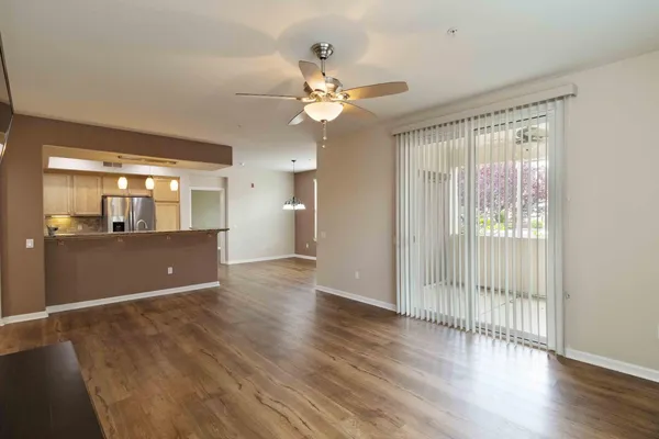 a view of a livingroom with wooden floor and a ceiling fan