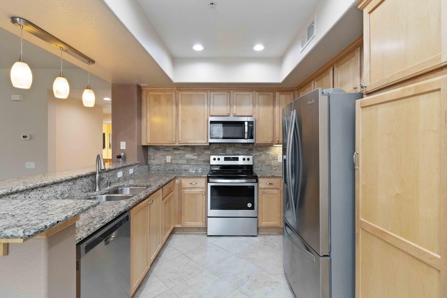 1550 Topanga Lane, Unit 101 Lincoln, CA 95648 - Photo 8 of 27 a kitchen with stainless steel appliances granite countertop a refrigerator and a stove top oven