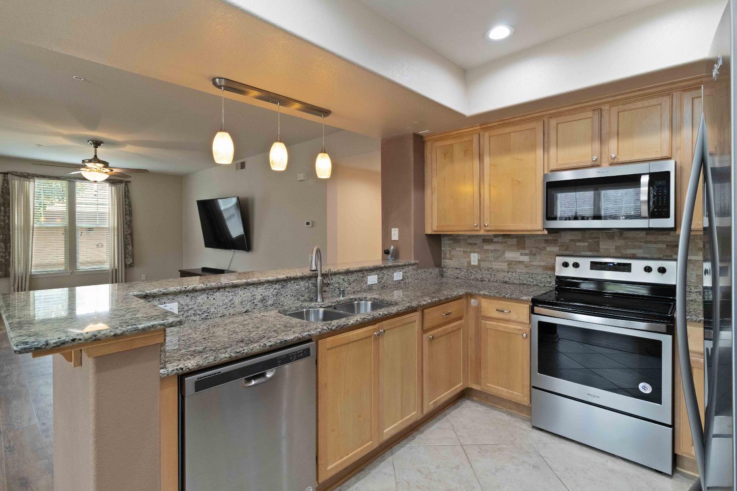 1550 Topanga Lane, Unit 101 Lincoln, CA 95648 - Photo 9 of 27 a kitchen with stainless steel appliances granite countertop a sink and stove top oven