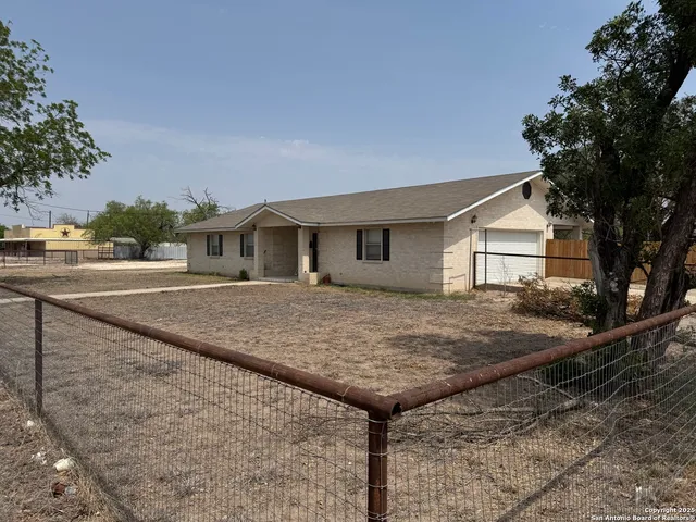 a view of house with yard and trees in the background
