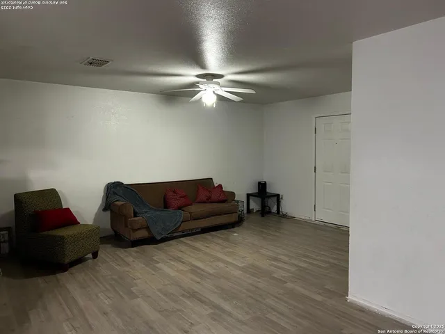 a living room with furniture and a ceiling fan