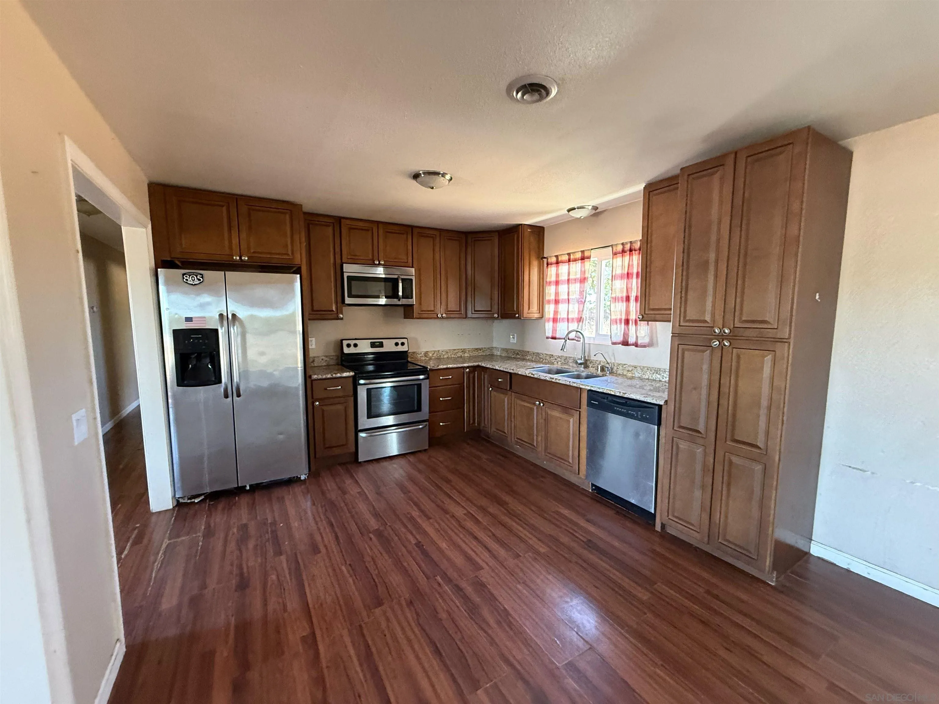 23273 Marsh Creek Road Brentwood, CA 94513 - Photo 5 of 8 a kitchen with stainless steel appliances granite countertop a refrigerator a sink dishwasher a stove with wooden floors and cabinets