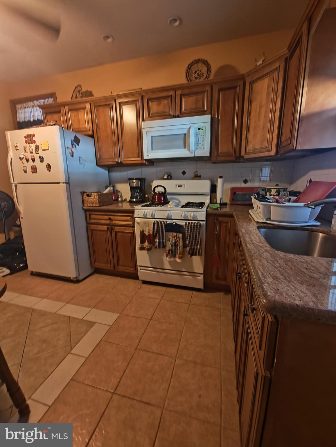 3274 Cedar Street Philadelphia, PA 19134 - Photo 6 of 18 a kitchen with stainless steel appliances granite countertop a stove a sink dishwasher and a refrigerator