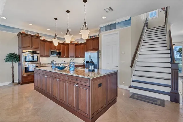 a kitchen with granite countertop a sink and a refrigerator