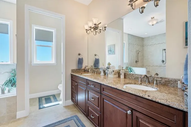 a spacious bathroom with a granite countertop sink a large mirror and a