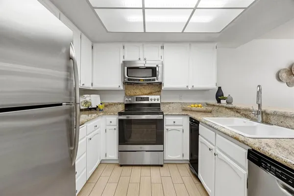 a kitchen with granite countertop a sink and steel appliances