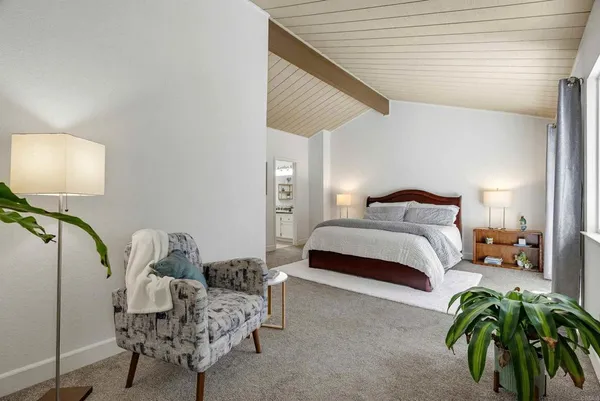 a bedroom with a bed and a potted plant