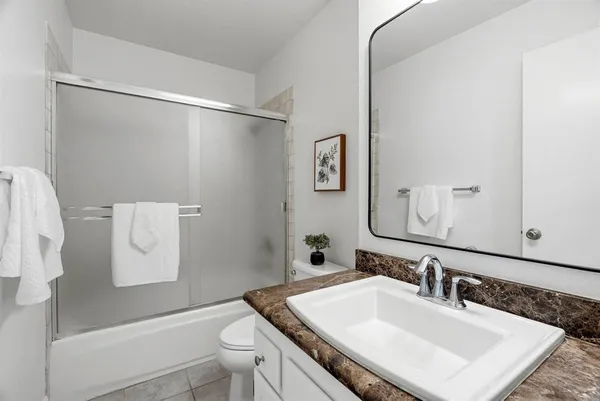 a bathroom with a sink vanity mirror and toilet