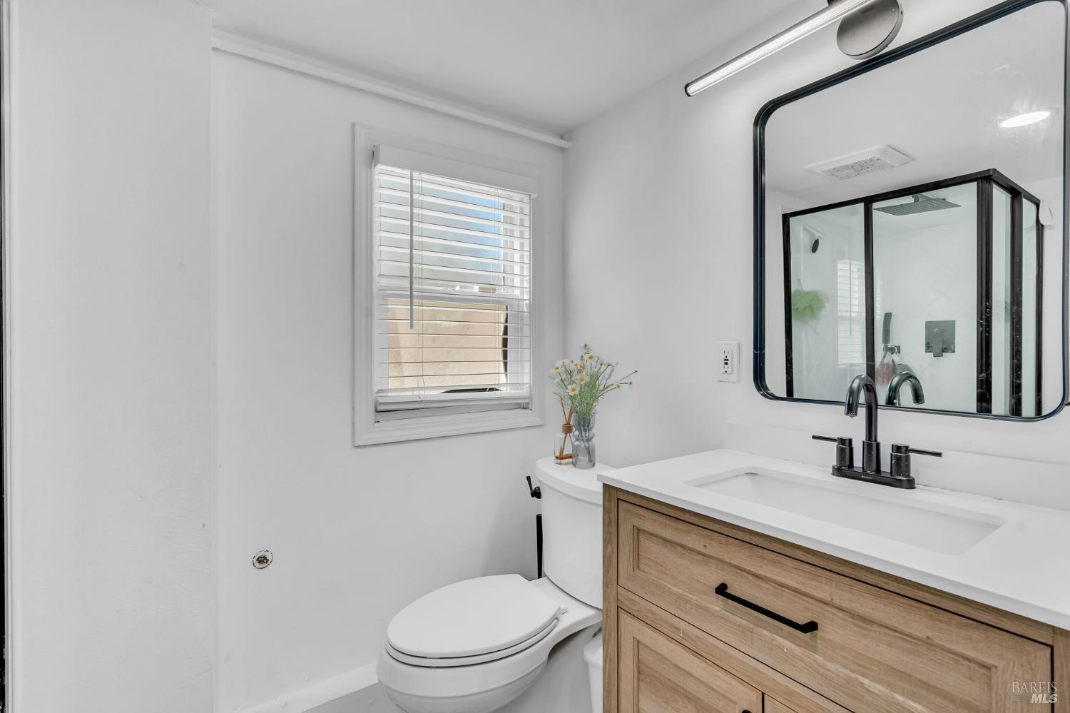 729 First Street Rodeo, CA 94572 - Photo 22 of 35 a bathroom with a sink a toilet a mirror and window