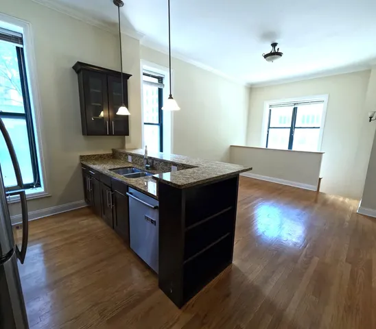 a kitchen with granite countertop a stove and a wooden floor