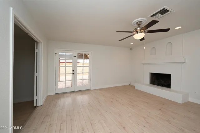 an empty room with windows and fireplace