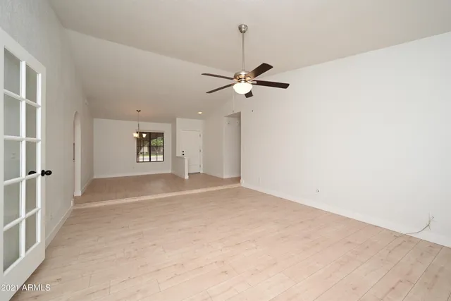 an empty room with an empty space and a ceiling fan