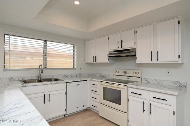 a kitchen with white cabinets and white appliances