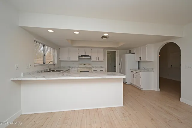 a large kitchen with stainless steel appliances granite countertop a large counter top a stove and a refrigerator