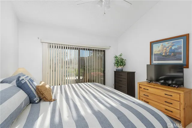 a bedroom with a bed and a flat tv screen on dresser